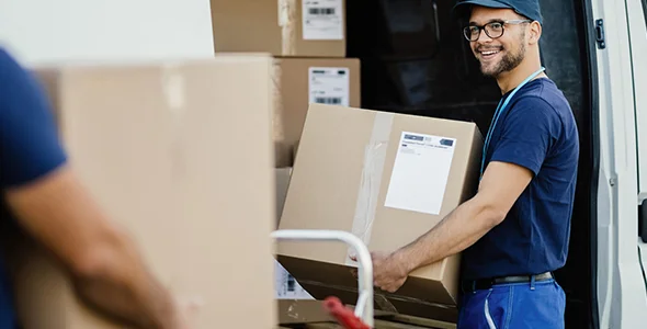 Smiling mover delivering a box for store-to-home delivery in La Porte, IN.